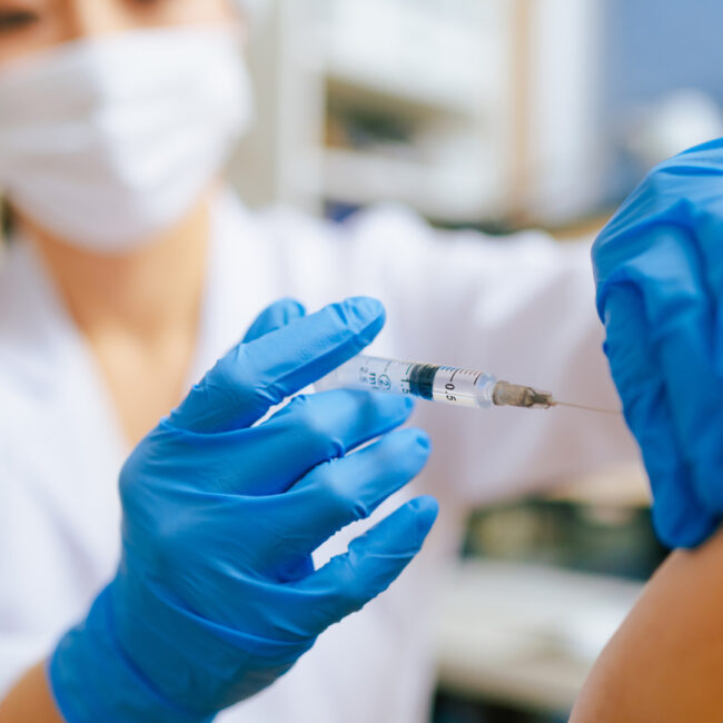 an image of a woman administering a vaccine
