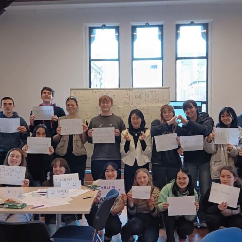 An image of the 2023 NA Study Tour participants holding up Korean messages