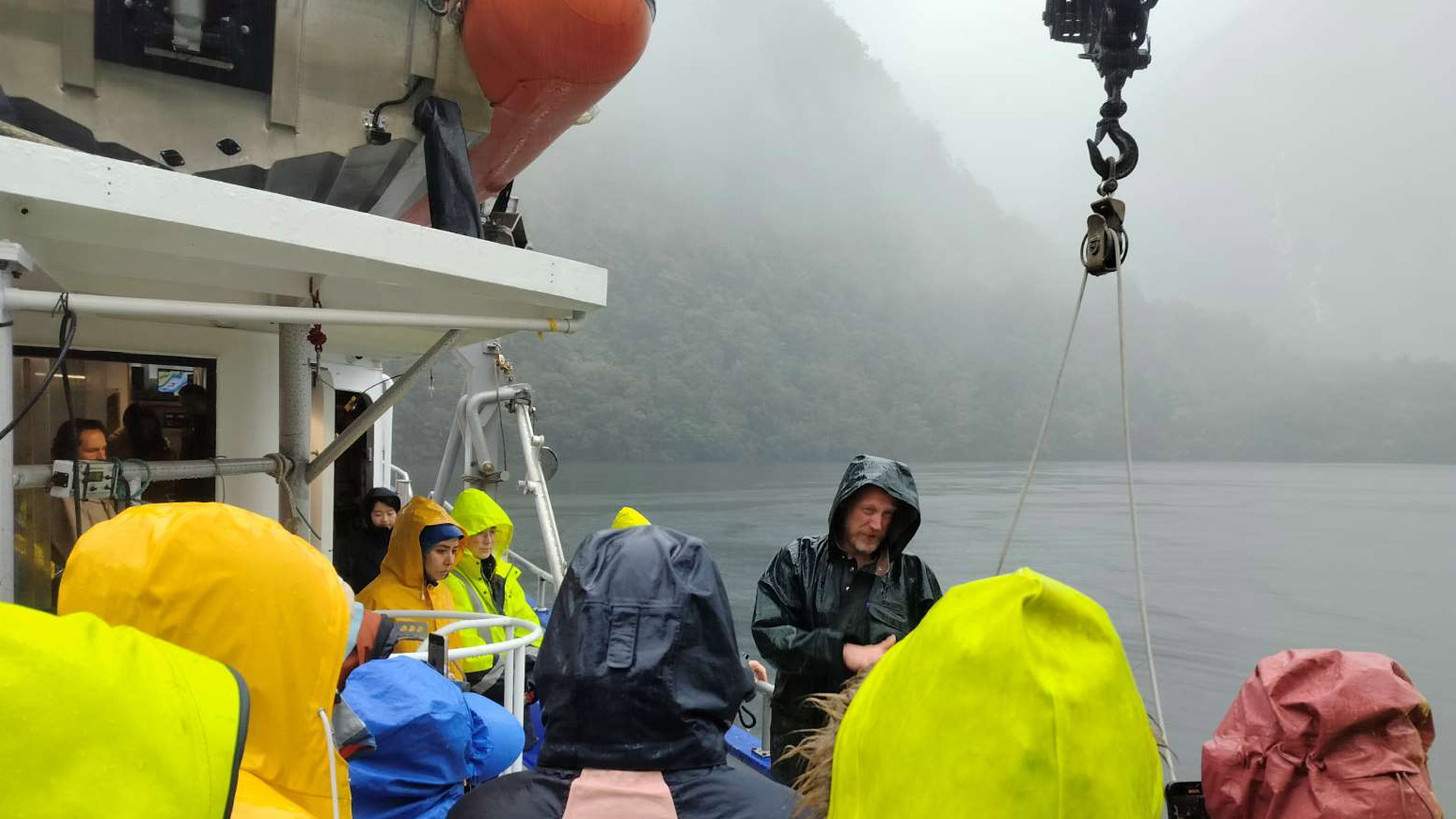 An image of our Winds of Change participants aboard a boat in DOubtful Sound on a very misty day